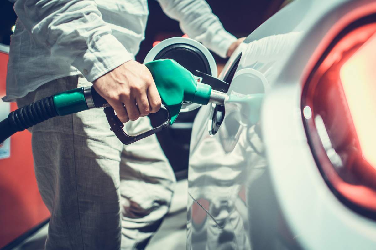 Caucasian Car Owner Refueling His Vehicle on a Gas Station. Automotive Theme.