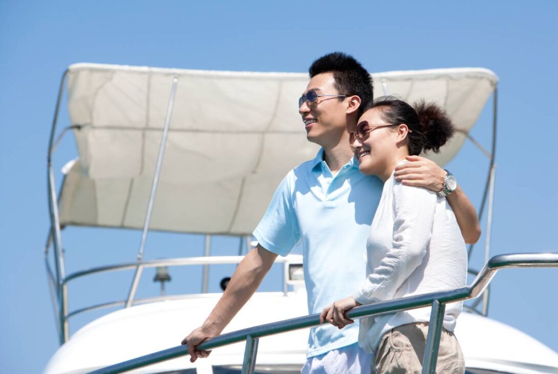 Chinese couple enjoying the view from the yacht deck