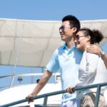 Chinese couple enjoying the view from the yacht deck
